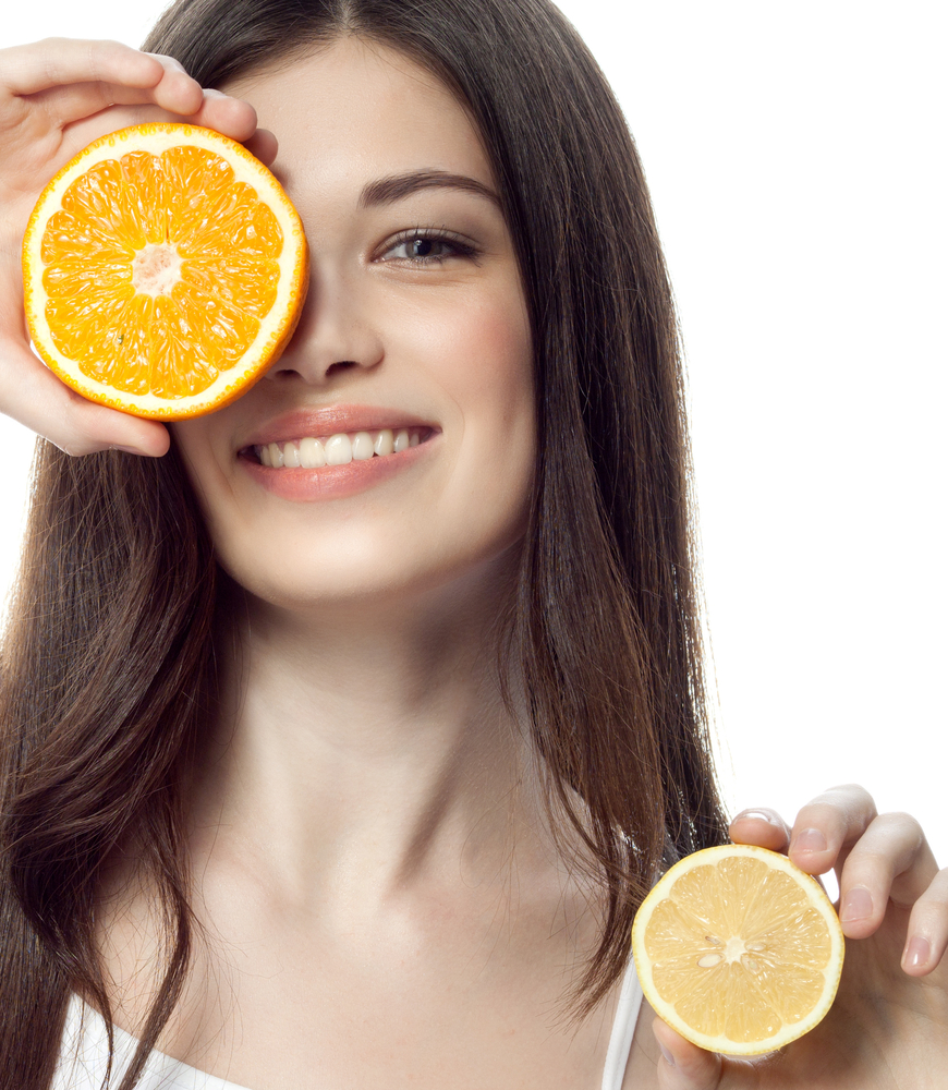 Woman holding citrus fruits. 